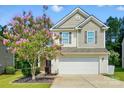 Inviting home featuring vinyl and shingle siding, a two-car garage, and a lovely flowering tree at 78114 Rillstone Dr, Lancaster, SC 29720