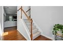 Carpeted staircase with white and wood railing, with hardwood floors and a glimpse into the living area at 78114 Rillstone Dr, Lancaster, SC 29720