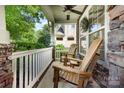 Relaxing front porch with stone pillars, ceiling fan, and cozy seating, perfect for enjoying the outdoors at 10237 Broken Stone Ct, Charlotte, NC 28214