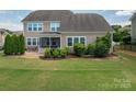 Spacious backyard with a screened porch, patio, and lush green lawn, perfect for outdoor living at 104 Wingstem Ct, Mooresville, NC 28117