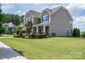 Attractive two-story home with a covered front porch, showcasing curb appeal with a green lawn at 104 Wingstem Ct, Mooresville, NC 28117