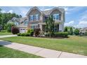 Beautiful two-story home with a well-maintained lawn and landscaping, including trees and shrubs at 104 Wingstem Ct, Mooresville, NC 28117