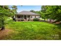 Expansive backyard with well-kept lawn, covered porch, and a charming black metal fence at 106 Pier Point Dr, Stony Point, NC 28678