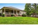 Charming back porch with white railings, ceiling fans, and access to a large backyard at 106 Pier Point Dr, Stony Point, NC 28678