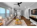 Open-concept living room with modern furniture and hardwood floors; kitchen in background at 11211 James Coy Rd, Huntersville, NC 28078