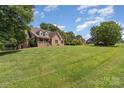 Spacious home with a large front yard on a sunny day at 135 Oak Creek Dr, Rockwell, NC 28138