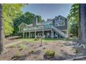 Expansive backyard with a multi-level deck, lush lawn, and mature trees provides a private oasis at 18205 Royal Oak Rd, Charlotte, NC 28278