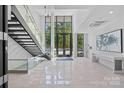 Bright lobby featuring a modern staircase, tile floors, and floor-to-ceiling windows at 19329 Watermark Dr # 422, Cornelius, NC 28031