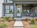 Inviting covered porch with seating area, ceiling fan, and well-maintained landscaping at 223 Halemarg Dr, Belmont, NC 28012