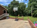 Spacious backyard with a basketball hoop, playset, and lush greenery, ideal for outdoor activities at 232 Harmony Hills Dr, Catawba, SC 29704
