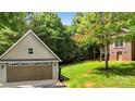 Detached garage with a large bay door and tidy landscaping at 234 Rivercliff Dr, Stony Point, NC 28678