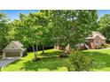 Exterior view of the property, showcasing the brick home, detached garage, and lush green lawn at 234 Rivercliff Dr, Stony Point, NC 28678