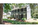 Classic two-story home featuring black shutters, beautiful landscaping, and ample natural light, on a sunny day at 3008 Heathcroft Ct, Charlotte, NC 28269