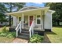 Covered porch of a gray house with chairs and gray stairs, plus well-maintained landscaping at 407 Rosemont Ave, Kannapolis, NC 28081