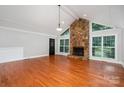 Bright living room with hardwood floors, stone fireplace, and many windows at 7613 Happy Hollow Dr, Mint Hill, NC 28227