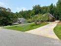 Beautiful brick home boasts a long driveway, meticulously maintained lawn, and mature trees at 11646 Hidden Forest Ln, Davidson, NC 28036
