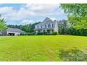 Traditional two-story home with a spacious lawn and mature trees, offering curb appeal at 11922 Kimberfield Rd, Matthews, NC 28105