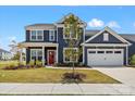 Charming two-story home with a manicured lawn, attached garage, and inviting red front door at 12205 Hollinhope Dr, Charlotte, NC 28278