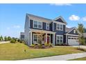 Beautiful two-story home with blue siding, white trim, a well-kept lawn, and an attached garage at 12205 Hollinhope Dr, Charlotte, NC 28278