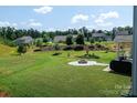 Expansive backyard with lush green grass, mature trees, and a cozy fire pit area at 171 Old Harbor Dr, Mount Gilead, NC 27306