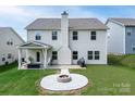 Large backyard featuring a stone fire pit and covered patio with seating, perfect for entertaining at 171 Old Harbor Dr, Mount Gilead, NC 27306