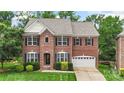 Well-maintained two-story red brick home with a lush green lawn at 1830 Alden Oaks Ln, Charlotte, NC 28270