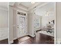 Elegant foyer with dark wood floors leading to an office space with french doors at 1830 Alden Oaks Ln, Charlotte, NC 28270