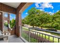 Relaxing balcony showcasing views of the street, green trees and landscaping, and bright blue skies at 1903 Kenilworth Ave # 104A, Charlotte, NC 28203