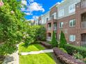 Charming brick building with well-maintained grounds, mature trees, colorful flowers, and private balcony at 1903 Kenilworth Ave # 104A, Charlotte, NC 28203