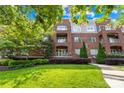 Beautiful brick condo building with lush landscaping and mature trees under a bright blue sky at 1903 Kenilworth Ave # 104A, Charlotte, NC 28203