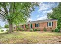 Well-maintained brick home showcasing traditional architecture, manicured shrubs and an established lawn at 1925 Montclair Ave, Gastonia, NC 28054