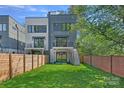 Fenced backyard featuring a lush lawn, small balcony, and a wooden fence for privacy at 209 Keswick Ave, Charlotte, NC 28206
