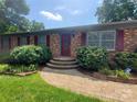 Charming brick home with updated landscaping and a paved walkway leading to the front entrance at 2104 Farmbrook Dr, Statesville, NC 28625