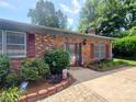 Well-maintained brick home featuring a welcoming front entrance and mature landscaping at 2104 Farmbrook Dr, Statesville, NC 28625