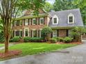 Charming two-story brick home with mature landscaping, black shutters, and a gray roof at 2432 Hartmill Ct, Charlotte, NC 28226