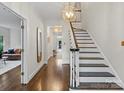 Bright foyer with hardwood floors, elegant staircase, and stylish lighting fixture at 2432 Hartmill Ct, Charlotte, NC 28226
