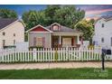 Charming home featuring a picket fence, red accent trim, and mature trees in a desirable neighborhood at 2723 Craddock Ave, Charlotte, NC 28208