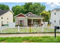 Charming single-story home with white picket fence, red trim, and cozy curb appeal at 2723 Craddock Ave, Charlotte, NC 28208