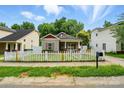 Charming single-story home with white picket fence, red trim, and cozy curb appeal at 2723 Craddock Ave, Charlotte, NC 28208