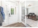 Inviting foyer with wood floors, showcasing an office through a glass French door at 2732 Berkhamstead Cir, Concord, NC 28027