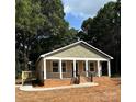 Inviting single-story home featuring a cozy porch, private deck, and landscaped yard surrounded by mature trees at 307 Wilson St, Monroe, NC 28112