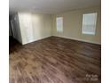 Bright living room with wood flooring and two windows offering plenty of natural light at 307 Wilson St, Monroe, NC 28112