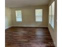 Bright living room featuring wood-look floors and plenty of natural light from large windows at 307 Wilson St, Monroe, NC 28112