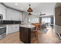Stylish kitchen with modern appliances, an island with seating, and an open view to the dining and living areas at 333 W Trade St # 1106, Charlotte, NC 28202