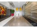 Modern building lobby with elegant marble floors, wood details, and an eye-catching decorative wall at 333 W Trade St # 1106, Charlotte, NC 28202