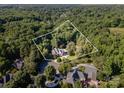 Aerial view of an estate nestled among lush greenery surrounded by mature trees at 3500 Cedar Springs Sw Dr, Concord, NC 28027