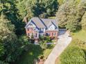 Overhead view of a brick home with mature trees, a long driveway, and an expansive lawn at 3500 Cedar Springs Sw Dr, Concord, NC 28027