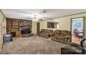Cozy living room featuring a stone fireplace, plush carpeting, and a neutral color scheme with an adjoining dining space at 4330 Rowell Rd, Lancaster, SC 29720