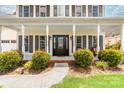 Inviting front porch with decorative columns, manicured bushes, and a pathway to the entrance at 4469 Greystone Sw Dr, Concord, NC 28027