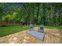 Serene backyard features a cozy deck with chairs and a swing, perfect for relaxation at 6215 Cross Creek Ln, Charlotte, NC 28212